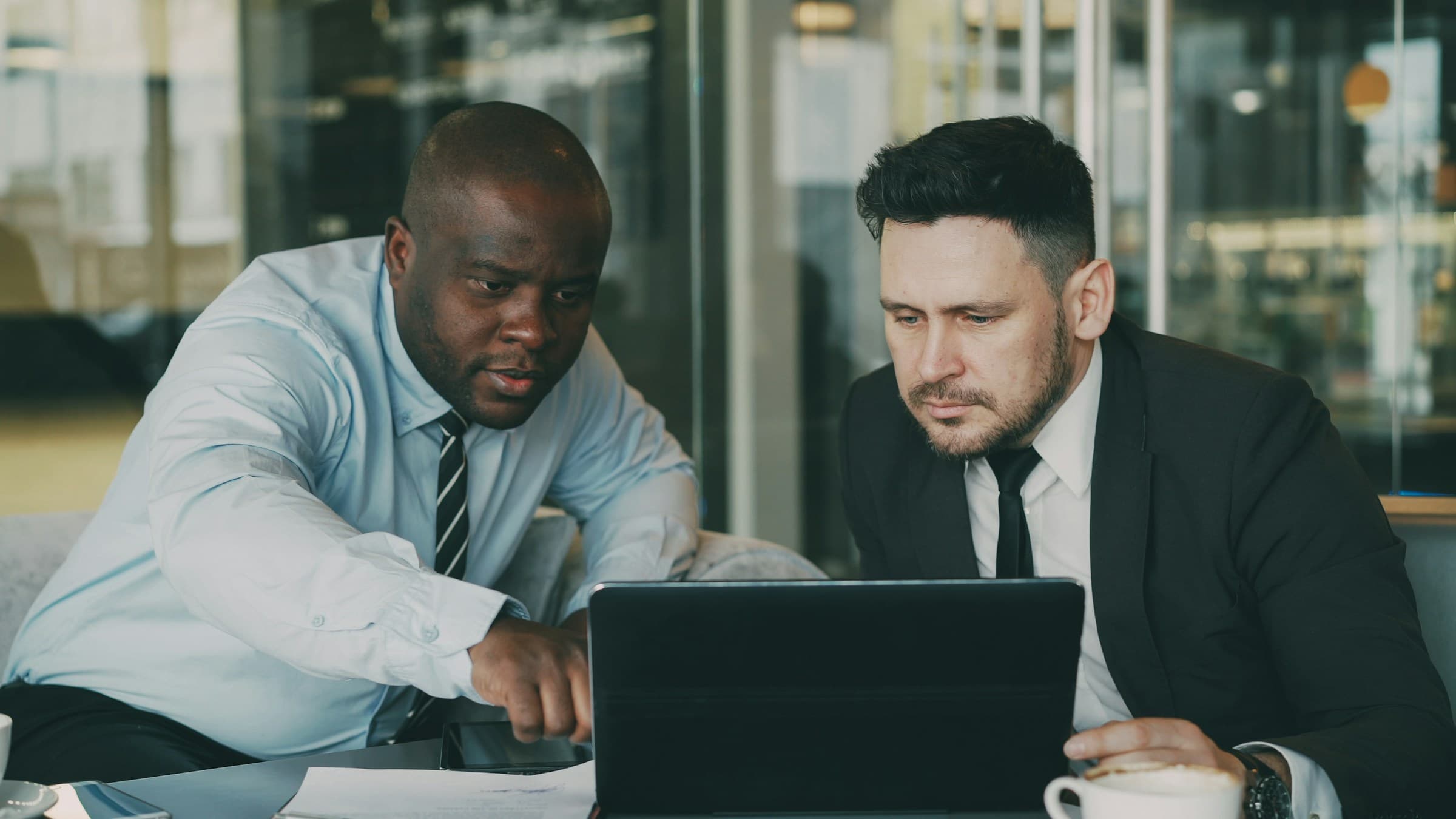 Two colleagues reviewing work together on a laptop